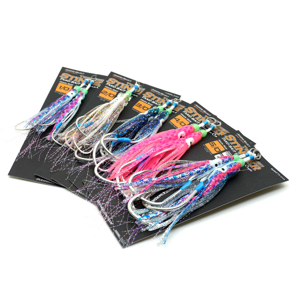 Five fishing lures in assorted bright colors, including pink, blue, purple, and silver, displayed on black retail cards against a white background. An AFTA 'Best in Show 2021' badge is visible in the lower-left corner.