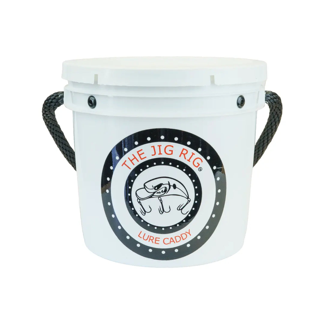 A white plastic bucket with black rope handles and a circular front logo that reads 'THE JIG RIG LURE CADDY' with a fish illustration, on a plain white background.