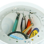 Close-up of fishing lures and accessories hanging from metal hooks inside a round white container or organizer.