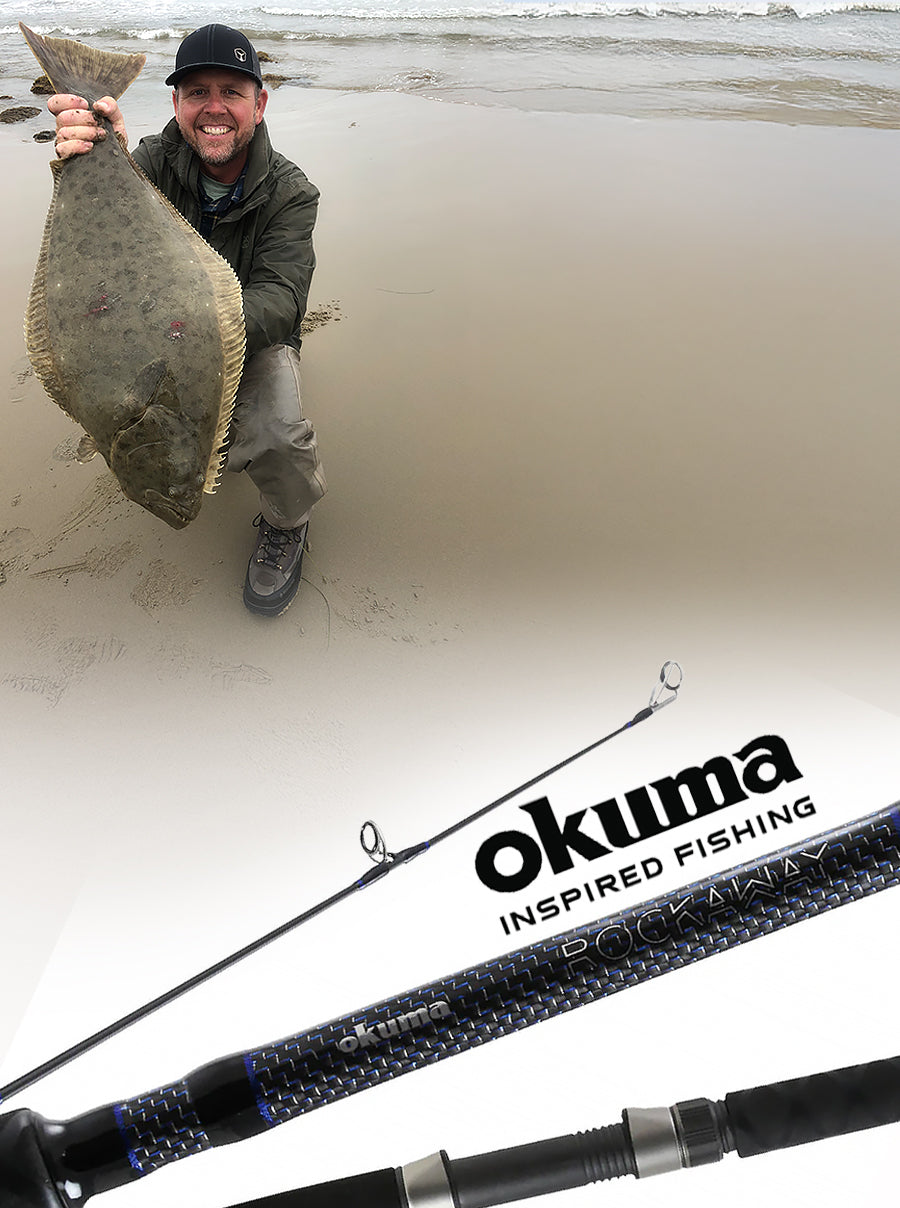 Man holding a halibut next to an Okuma Rockaway fishing rod on a sandy background