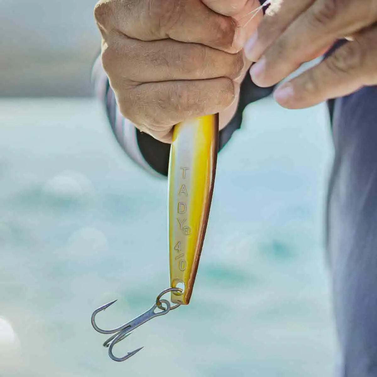 Close-up of a hand holding a fishing lure with a blurred background