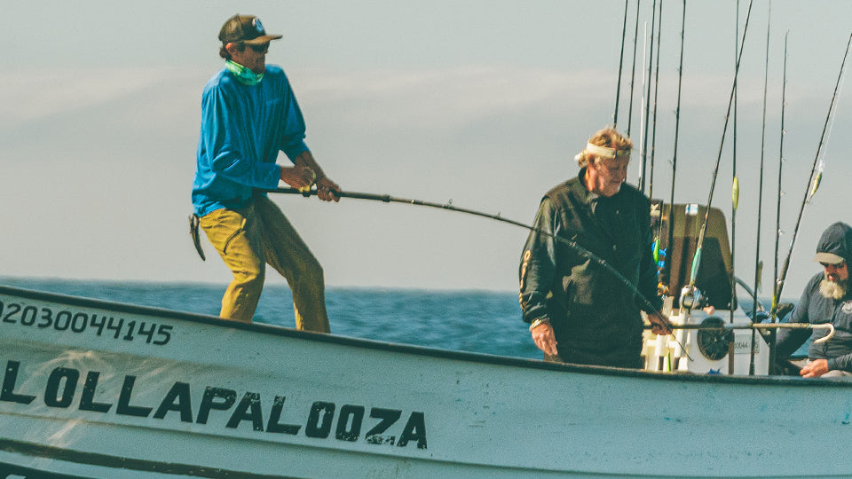 People on a boat named 'Lollapalooza' in the ocean.