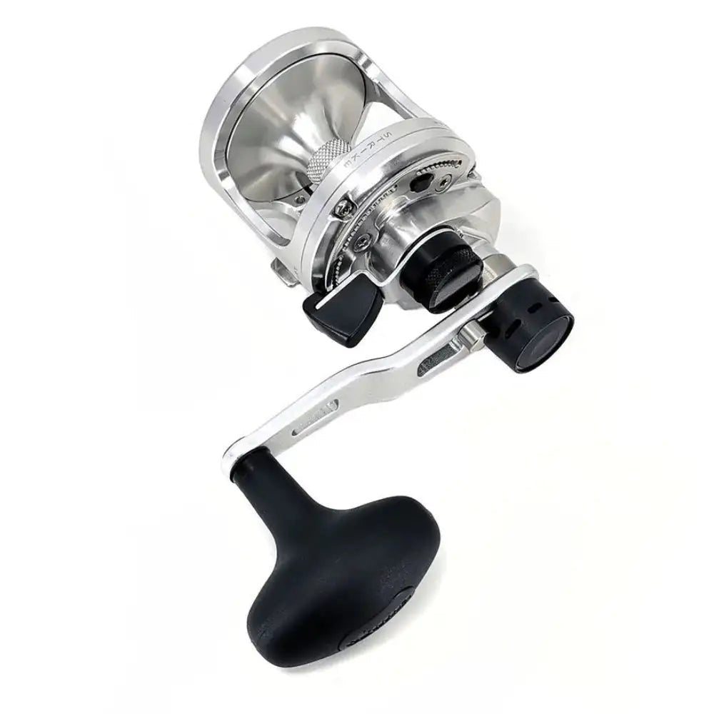Fishing reel with metallic body and black handle on a white background