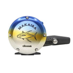 A Makaira fishing reel with a blue-to-yellow gradient top half, a yellow fish graphic, and a black handle, shown on a plain white background.