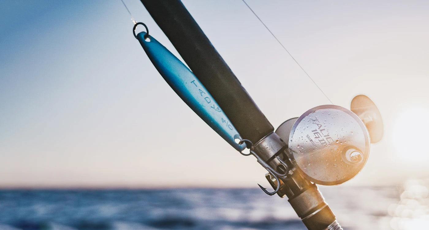 Fishing rod with reel and jig on a blurred ocean background